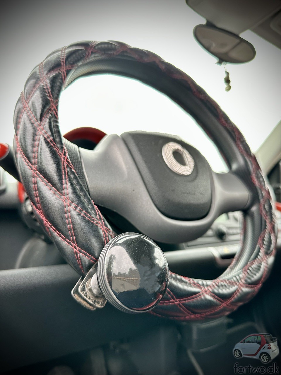 Steering wheel cover with red stitches, and a Steering wheel knob.