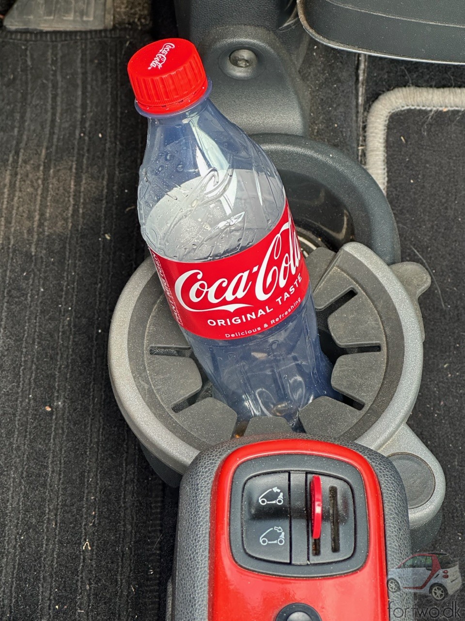 Original Smart Fortwo dual cupholder, with a 0,5 litre coca-cola bottle.