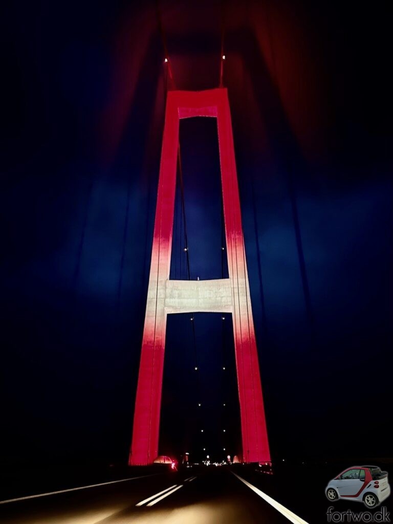 The Great Belt Bridge is lit up in the same red and white colours as my Smart Fortwo